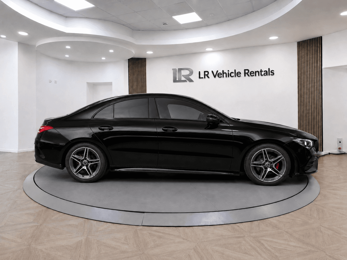 Black Mercedes-Benz CLA in profile, showing the four-door coupé roofline and AMG alloy wheels